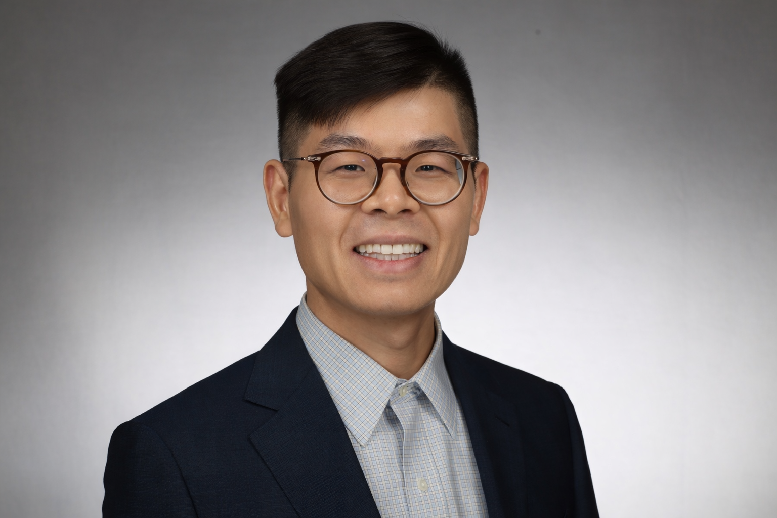 Richard Xu, wearing glasses and a navy blazer
